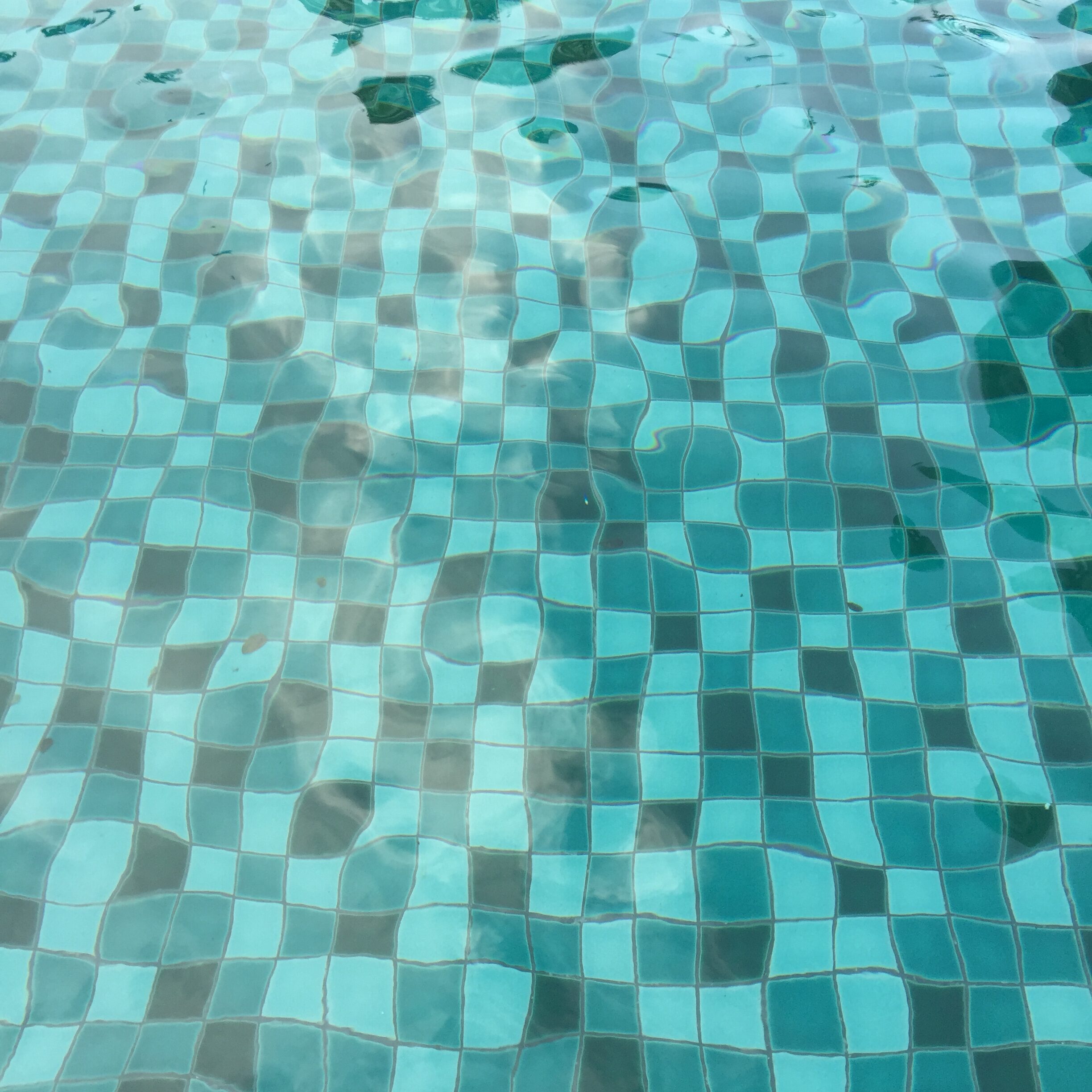 Pool tiles reflecting the shimmering water, adding to the aesthetic appeal of the pool.