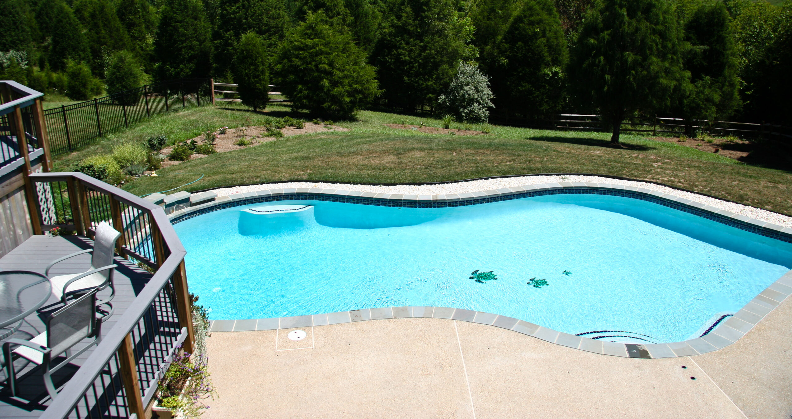 Backyard Pool in summer with surrounding multi-level deck