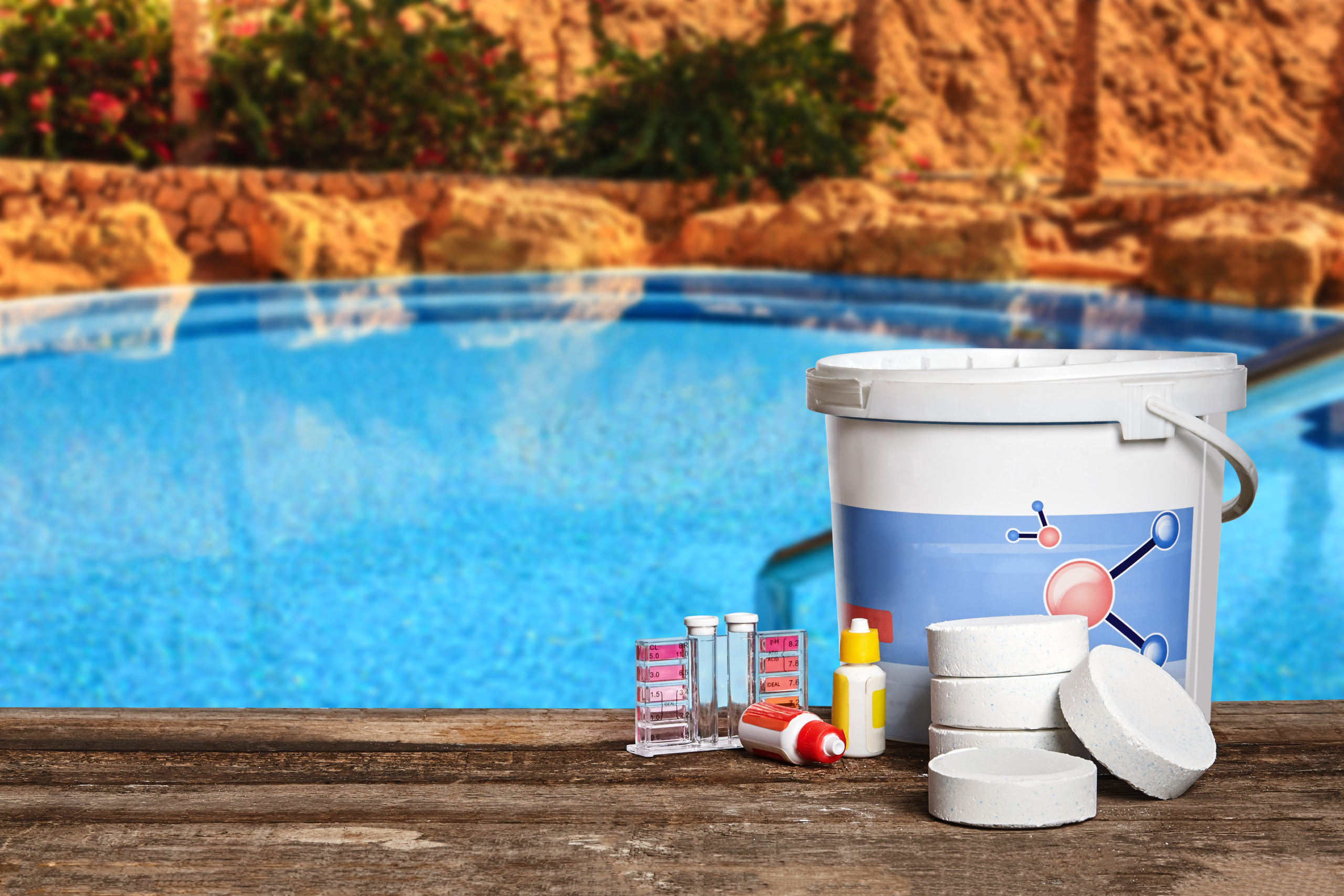 Various cleaning materials and tools used for pool maintenance, including brushes, skimmers, vacuum equipment, and chemicals