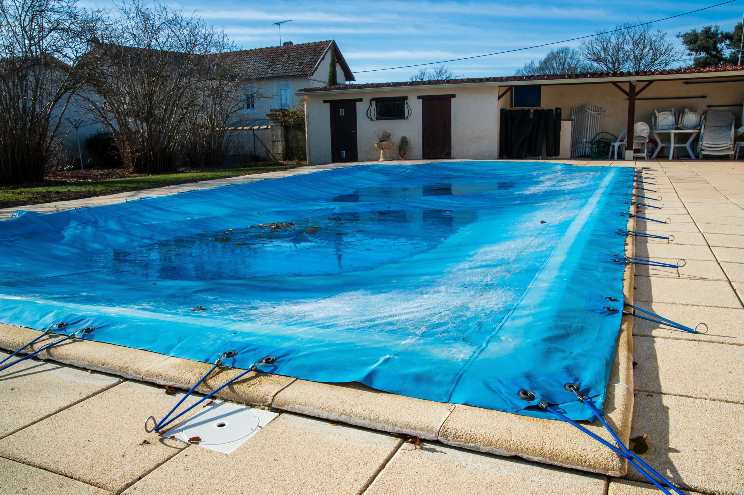 A pool covered with a protective pool cover, safeguarding the water from debris and helping to retain heat when the pool is not in use