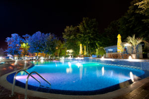 Hotel pool illuminated by artificial lighting at night