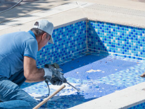 Men repairing swimming pool on the residential building courtyard