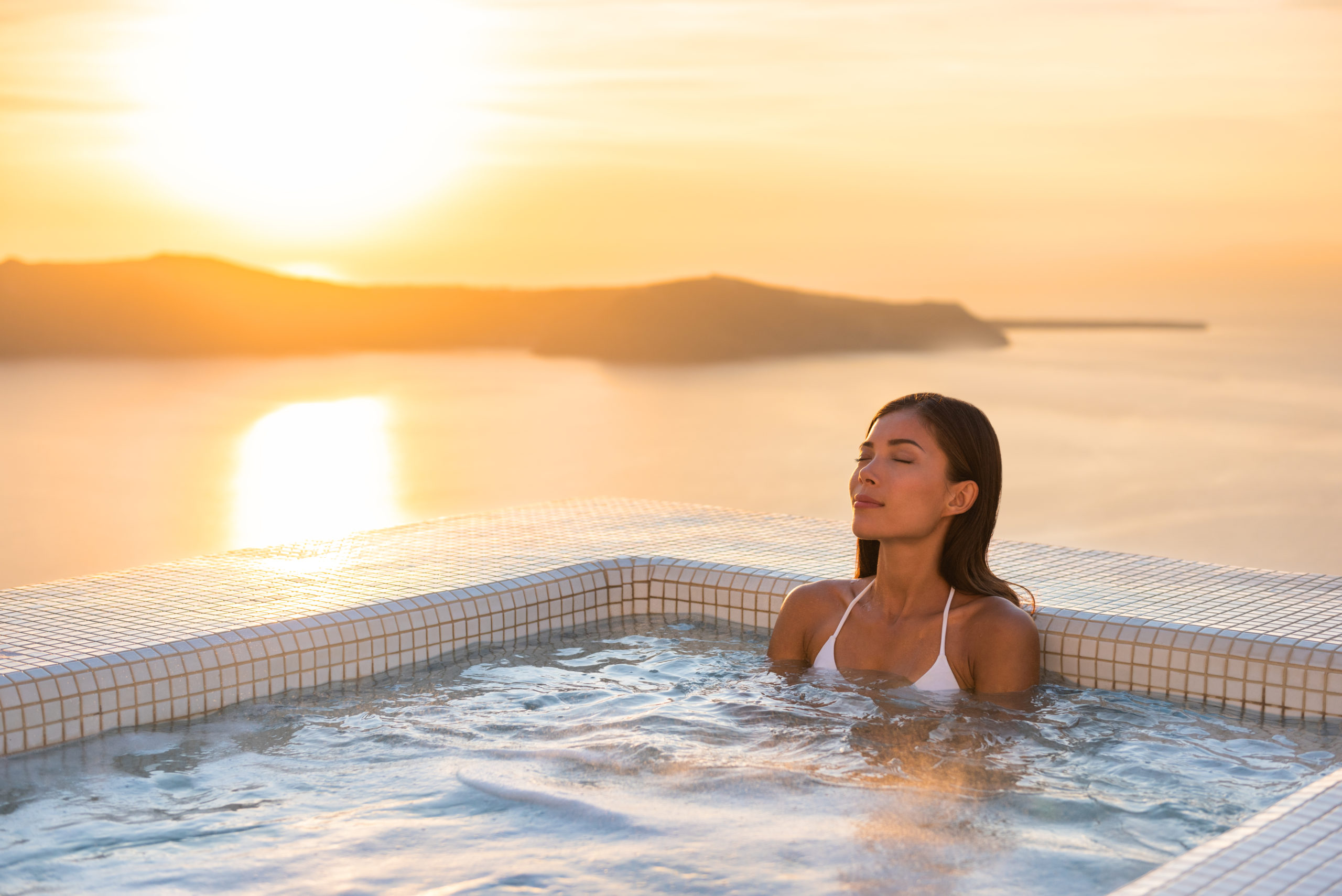 A woman relaxing by the pool at sunset, enjoying a serene and tranquil moment