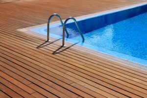 blue swimming pool with teak wood flooring stripes summer vacation