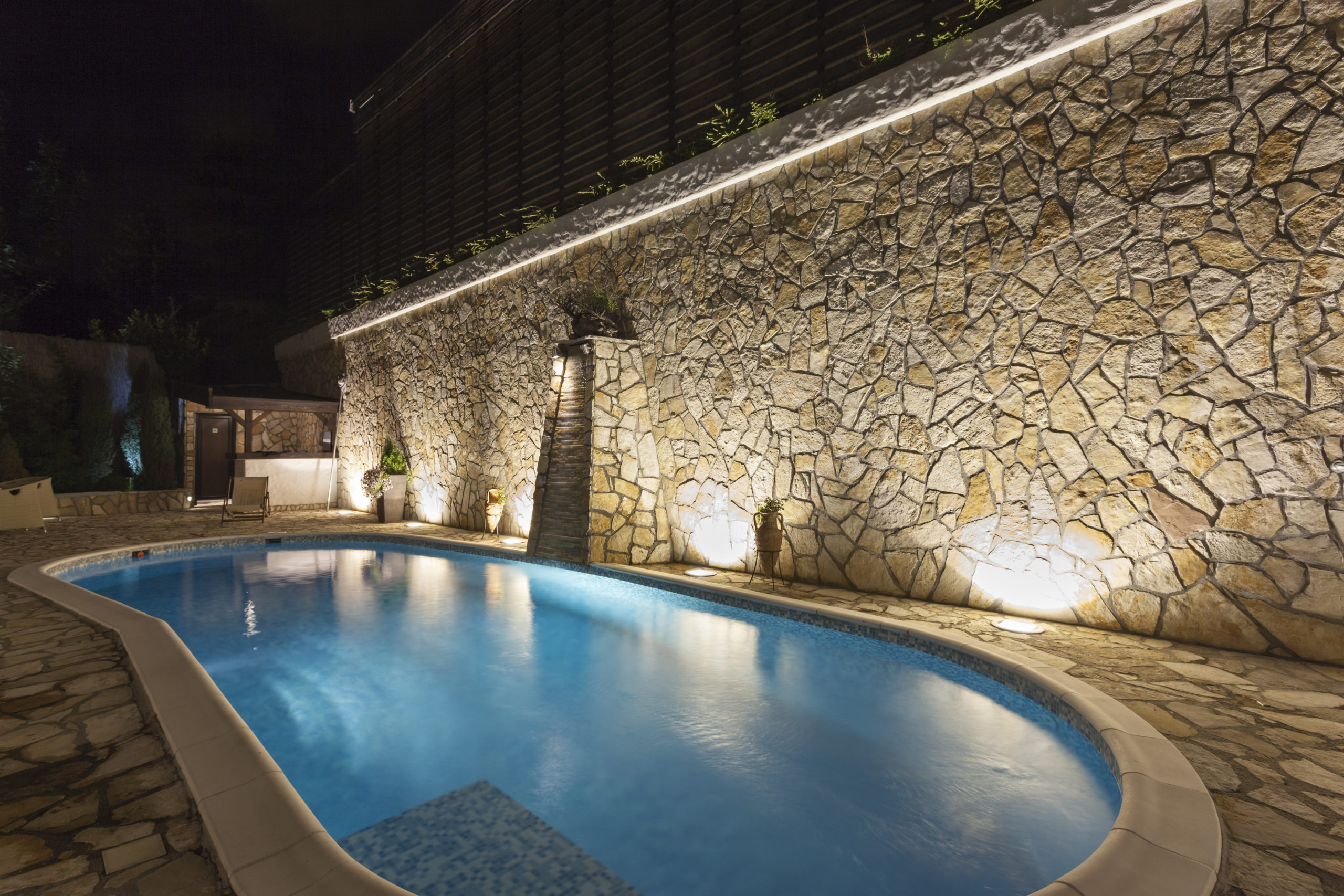 A nighttime swimming pool illuminated with vibrant lights, creating a captivating and colorful ambiance